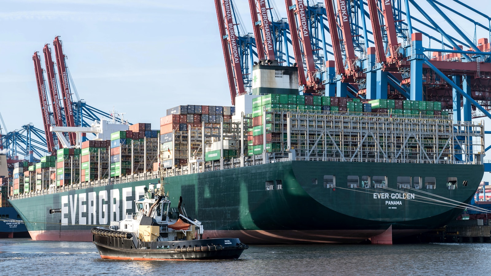 港口中的大型集装箱船与拖船